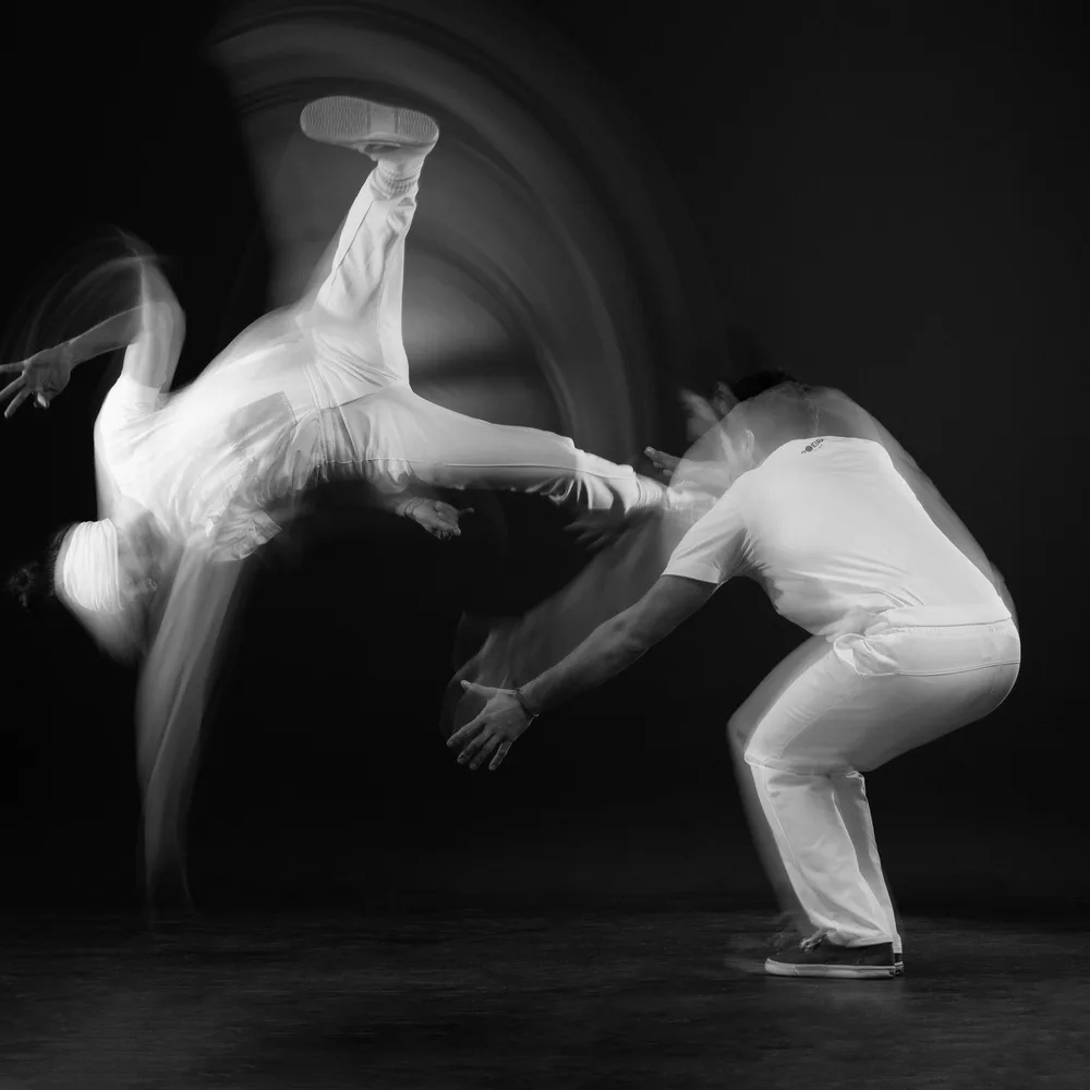 Zwei Capoeiristas in Bewegung, Langzeitbelichtung in Schwarzweiß