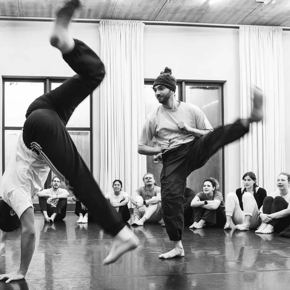 A kick in the capoeira game, surrounded by the roda