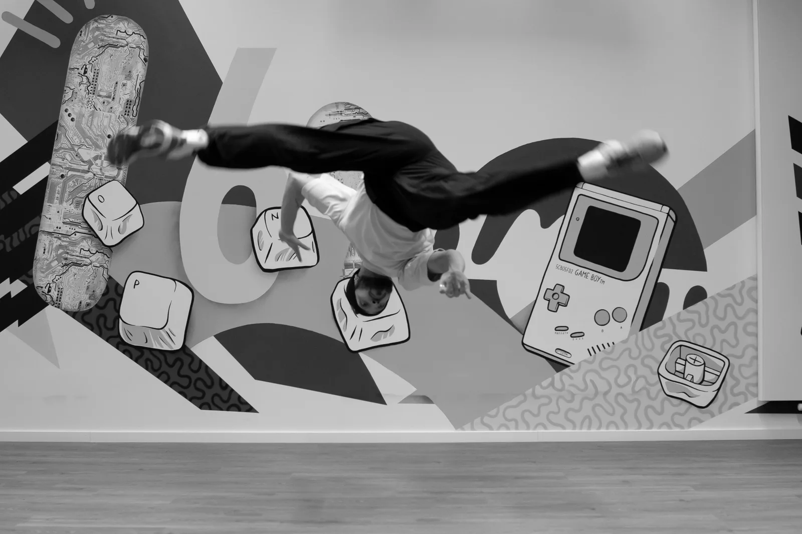 A no-handed cartwheel (au sem mão) in front of a mural